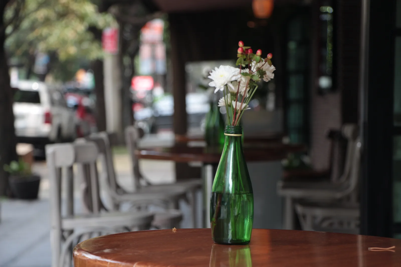 Klein bloemvaasje op een bistrotafel buiten