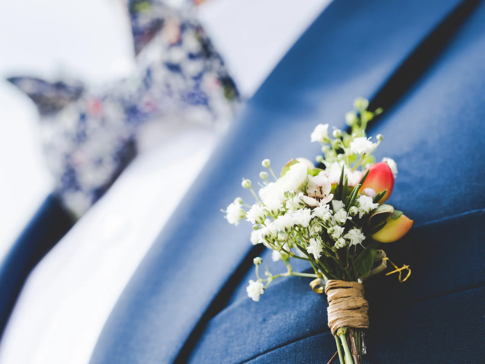 Witte corsage gespeld op een blauwe revers