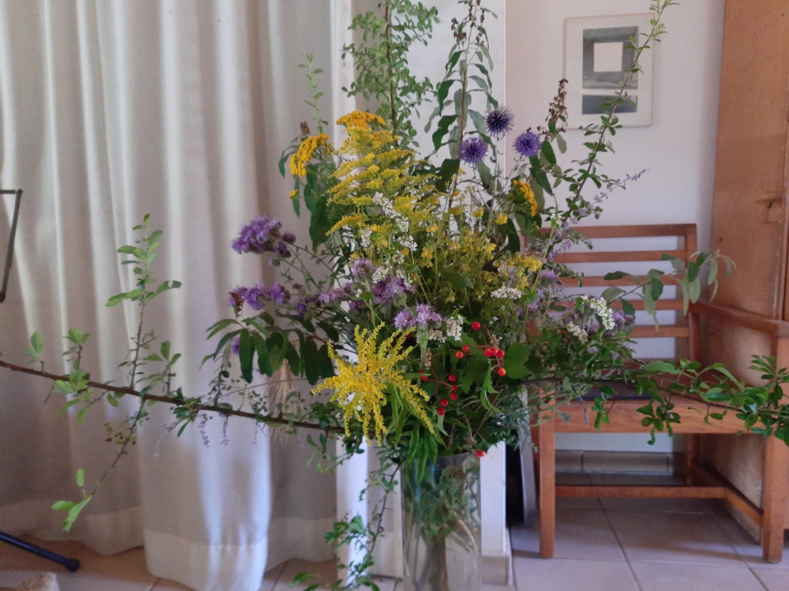 Los veldboeket met wilde bloemen bij het raam